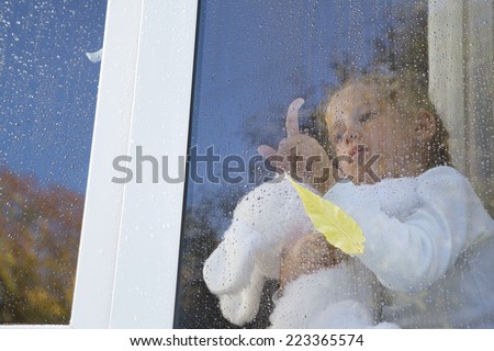 Little girl sad sitting in window finger by drawing by glasslittle girl be sad sitting on a window