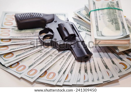Gun with money closeup on white table