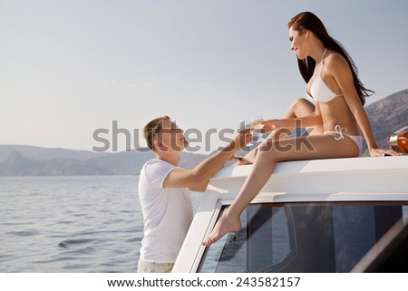 Happy couple on a yacht in the summer of celebrating honeymoon
