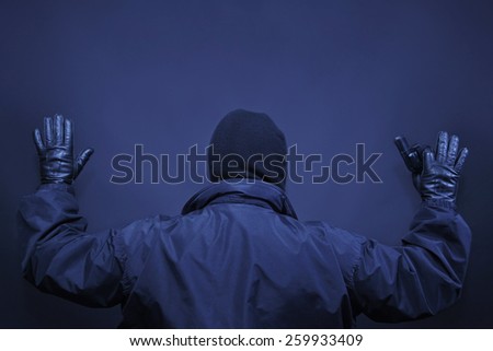 Man offender surrendered arms up back view