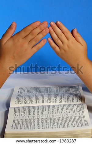 praying hands over the bible