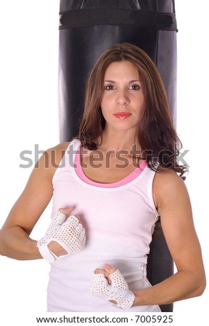 Fitness girl flexing in front of punching bag vertical