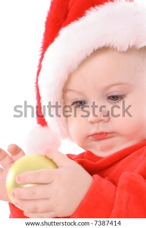 baby with santa hat holding ornament