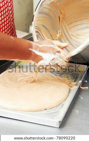 The workers pour the prepared ingredient of a cake to th places