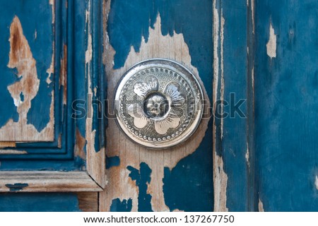 Silver metal door knob on an old wooden door