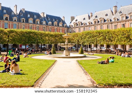 PARIS FRANCE SEPTEMBER 24 People relaxing on green lawns of the famous Place des Vosges the oldest planned square in Paris located in Marais district on September 24 2013 in Paris PARIS FRANCE SEPTEMBER 24 People relaxing on green lawns of the famous Place des Vosges the oldest planned square in Paris located in Marais district on September 24 2013 in Paris