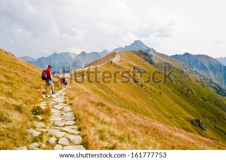 KASPROWY WIERCH, POLAND - SEPTEMBER 3: A man equipped for hiking standing on the walking path in Tatra mountains and looking at view on September 3, 2012 on Kasprowy Wierch, Poland.