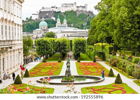 Salzburg Austria July 4 2013 Visitors are walking in beautiful Mirabell Gardens a castle Hohensalzburg is seen on the background Salzburg Austria July 4 2013 Visitors are walking in beautiful Mirabell Gardens a castle Hohensalzburg is seen on the background