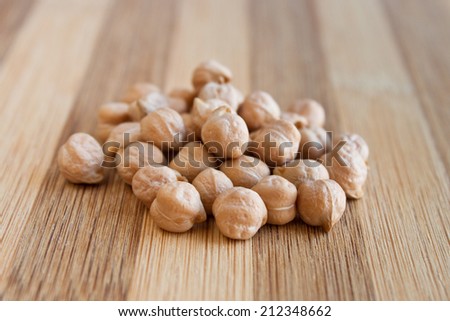 Heap of raw dried white chickpeas on a wooden table