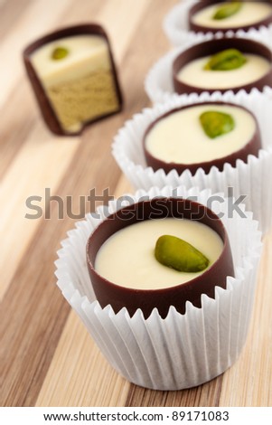 chocolate candies with filling and pistachio in paper cups