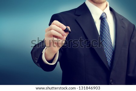 Business man holding a pen on blue background