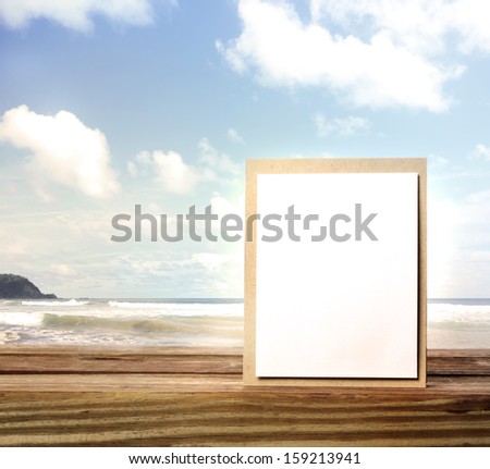 Handmade card on wooden table over blue sky background