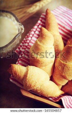 Croissant with milk and wheat on rustic wooden table