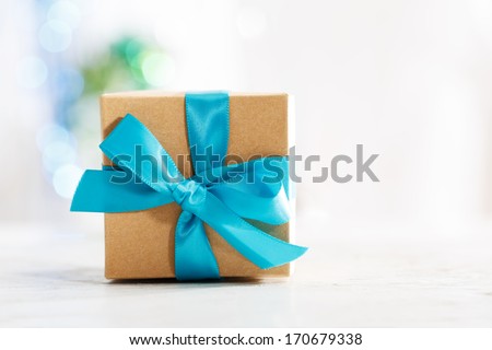 Gift box with blue ribbon in white wall room