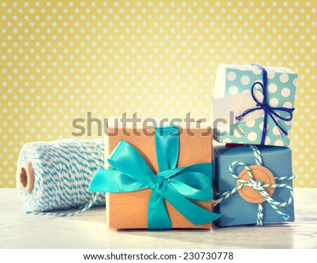 Light blue handmade gift boxes over polka dots background