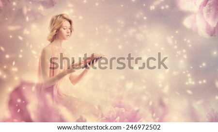 Young woman reading a book in pink peony fantasy environment