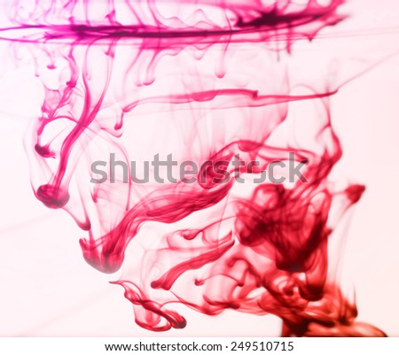 Red ink drops swirling in the water