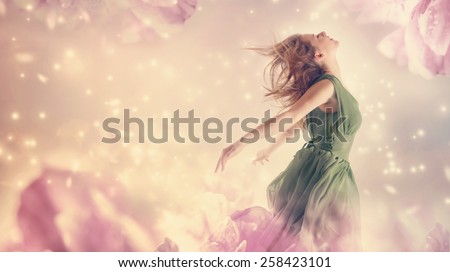 Beautiful woman in a green dress in a pink peony flower fantasy