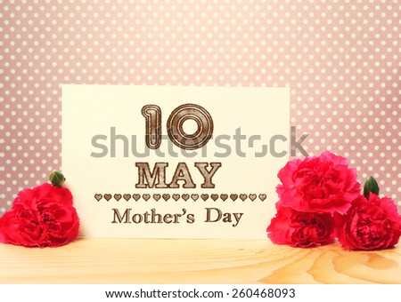 Mothers Day May 10th Card with Carnation Flowers on Top of a Wooden Table