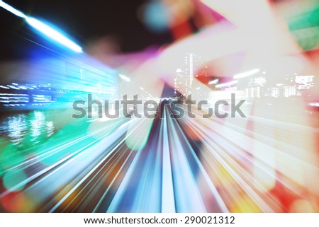 Automated guide-way train at night through the city lights