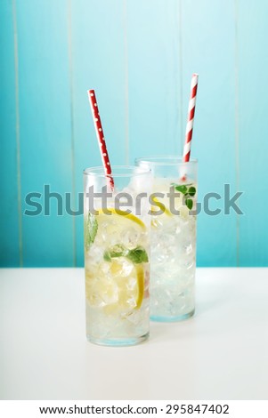 Homemade lemonade in glasses with big red paper straws