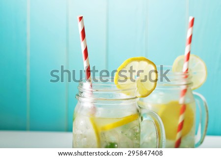 Homemade lemonade in mason jars with big red striped straws