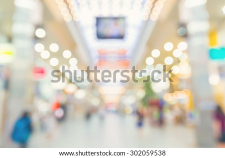 Defocused shopping mall interior with people walking at night