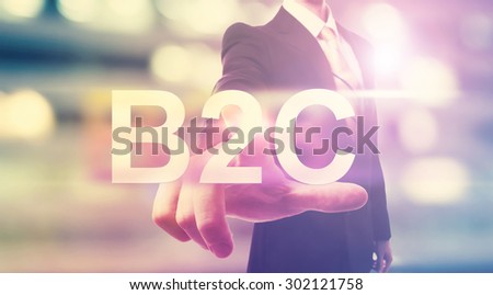 Businessman pointing at B2C (business to consumer) on blurred city background