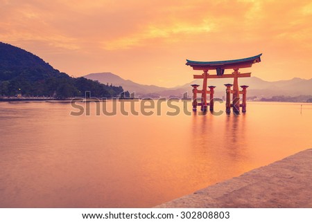 The famous orange floating shinto gate (Torii) of Itsukushima shrine, Miyajima island of Hiroshima prefecture, Japan at sunset.