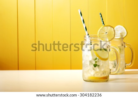 Homemade lemonade in mason jars with big green paper straw