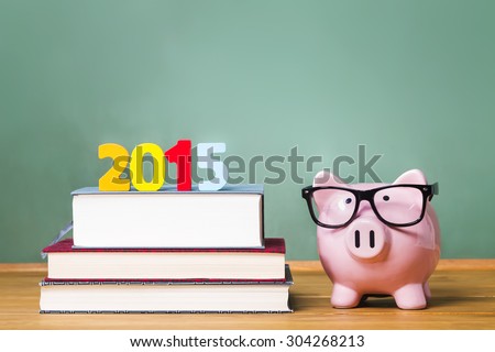 Class of 2015 theme with textbooks and piggy bank with glasses on green chalkboard background