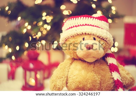 Bear wearing Santa hat with Christmas gift boxes at night