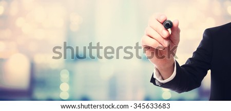 Businessman drawing something with a black maker on blurred abstract background