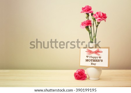 Mothers day message with pink carnations in a white vase