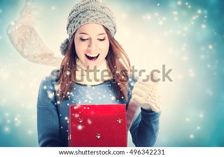 Happy young woman opening a Christmas present box