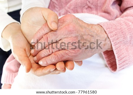 Old and Young Hands over White Blanket