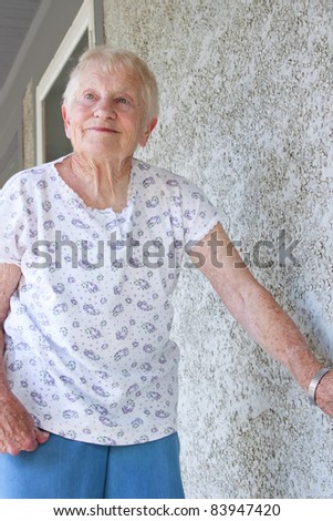 Happy senior lady standing on porch