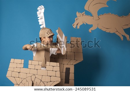 photo of the boy in medieval knight costume made of cardboards photo of the boy in medieval knight costume made of cardboards