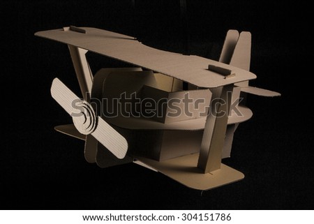 Photo of  cardboard plane on black background. Biplane.