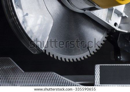 miter saw. Cutting disk on black background.