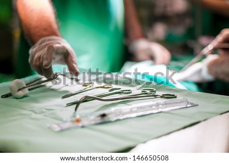 Doctor taking surgery tools from the table