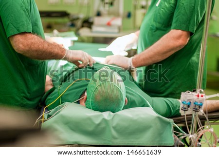 Two doctors making surgery to patient
