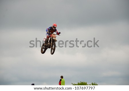 RUSSIA, SAMARA - JUNE 11: The spectacular jump motocross racer A. Nikishkin on the background a stormy sky the Open class the Regional Motocross Championship on June 11, 2012 in Samara, Russia