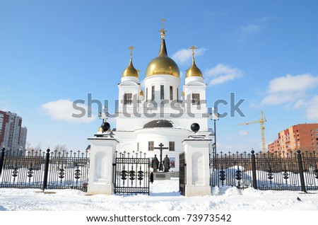 RUSSIA, SAMARA - MARCH 19: White cathedral with golden domes of the forged fence in the winter on a sunny day March 19, 2011 in Samara, Russia
