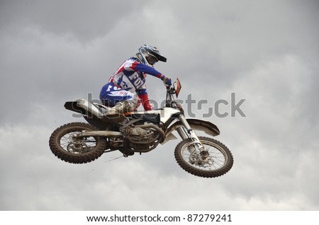 RUSSIA, SAMARA, CHAPAYEVSK - OCTOBER 17: The spectacular jump motocross racer A.Nikihkin on the background a stormy sky the Open Cup \