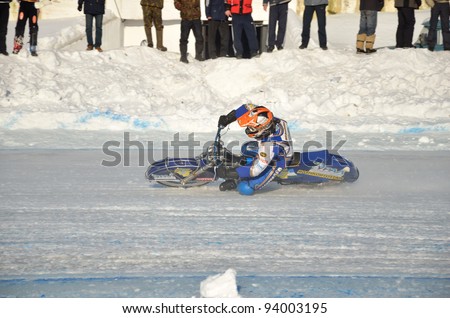 SAMARA, RUSSIA - JANUARY 27: Racing on ice, the unidentified driver of a motorcycle with spikes rotates with a large slope on one knee on the ice speedway Championship January 27, 2012 in Samara, Russia