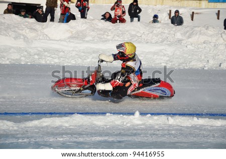 SAMARA, RUSSIA - JANUARY 29: Racing on ice, the unknown driver of a motorcycle with spikes rotates with a large slope on one knee ice speedway Championship January 29, 2012 in Samara, Russia