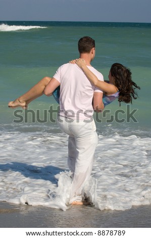 Attractive Brunette Man Carrying Woman at the Beach
