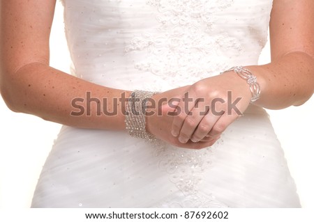 Beautiful bride\'s hands clasped in her gown in the studio