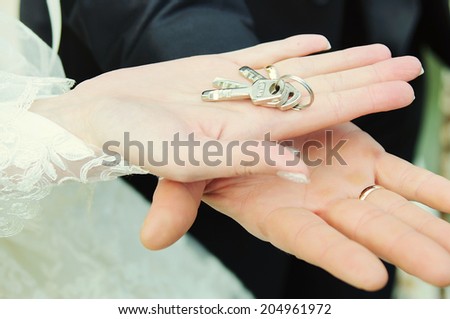 The lock with keys in hands of the groom and the bride